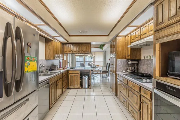 a kitchen with stainless steel appliances granite countertop a stove a sink and a refrigerator