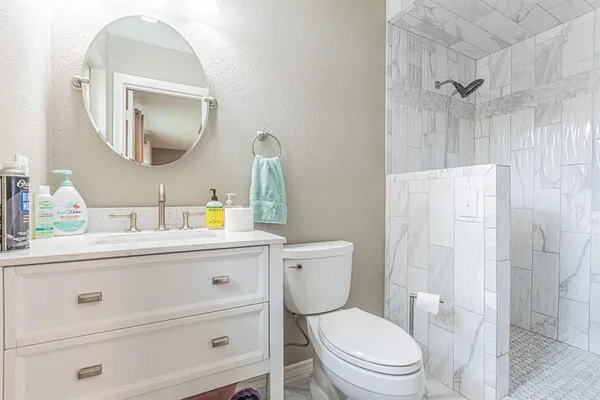 a bathroom with a toilet a sink a vanity and mirror