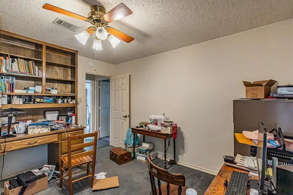 a view of a workspace with furniture and a bookshelf