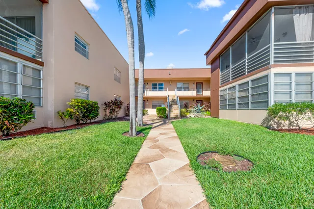 a front view of a house with a yard and potted plants