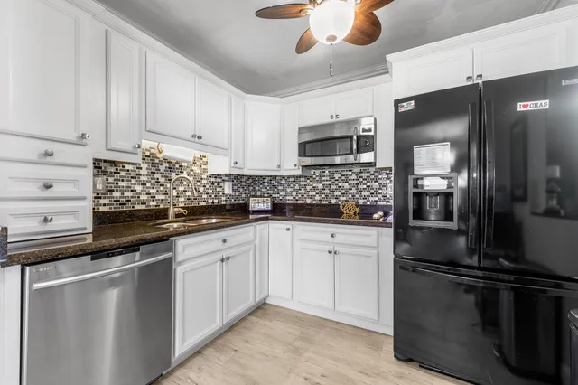 a kitchen with granite countertop white cabinets and stainless steel appliances