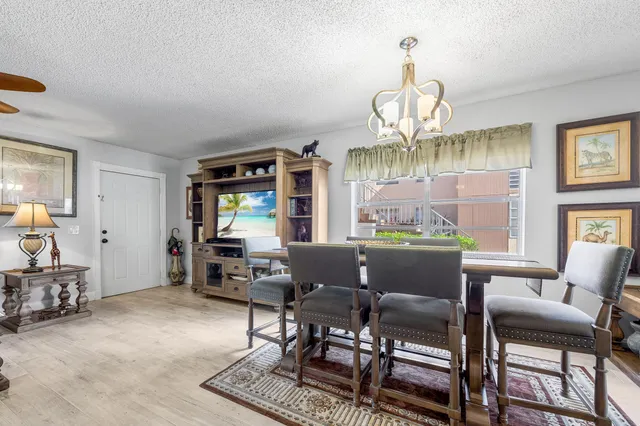 a dining room with furniture a rug and a chandelier