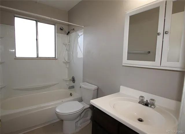 an empty room with a chandelier fan and windows