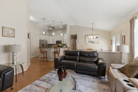 a living room with furniture and kitchen view