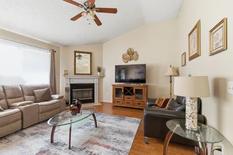 a living room with furniture a fireplace and a flat screen tv