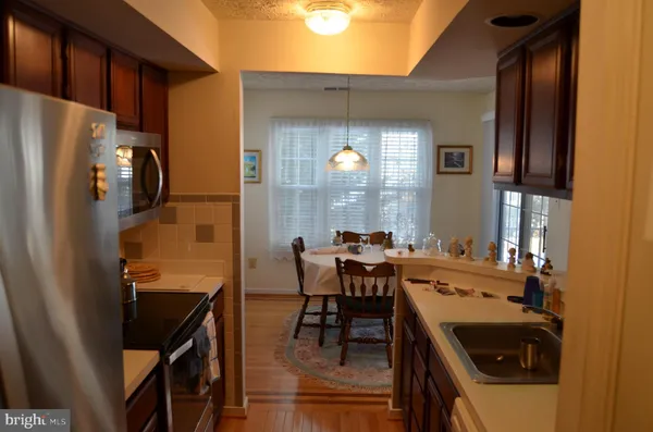 a kitchen with a sink a counter top space and stainless steel appliances