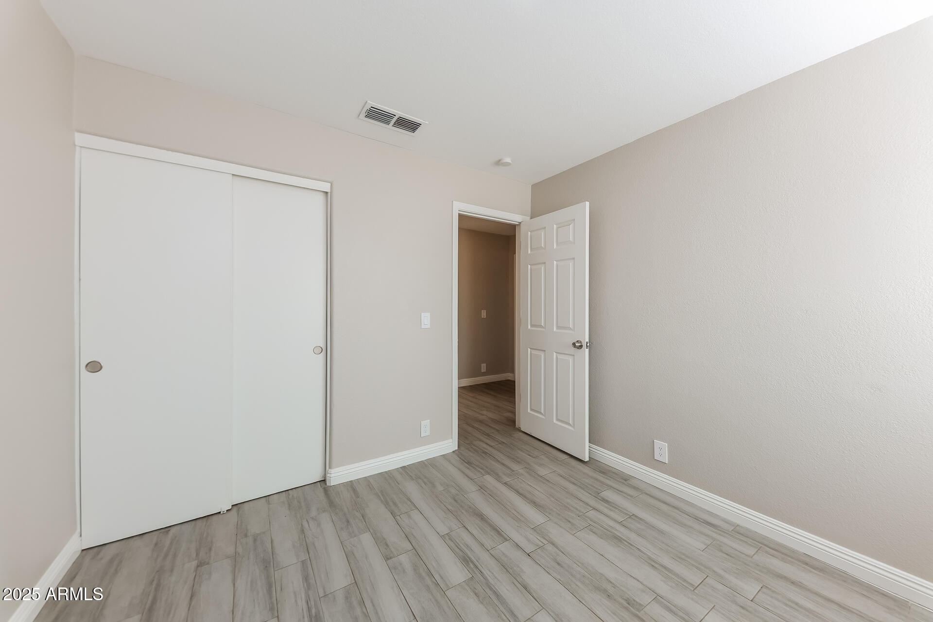 8833 West Monte Vista Road Phoenix, AZ 85037 - Photo 13 of 21 a view of an empty room with wooden floor
