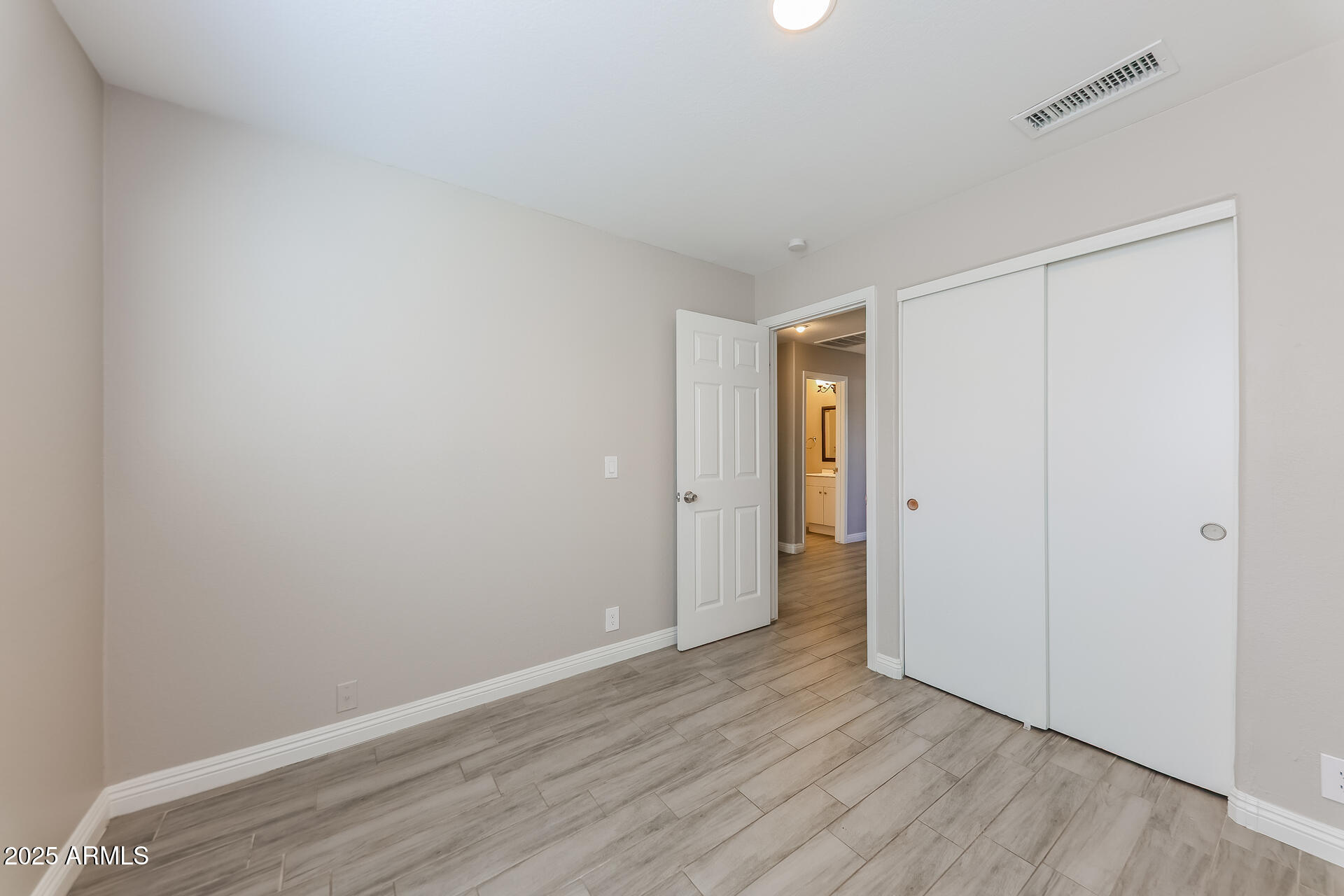 8833 West Monte Vista Road Phoenix, AZ 85037 - Photo 15 of 21 a view of an empty room with wooden floor