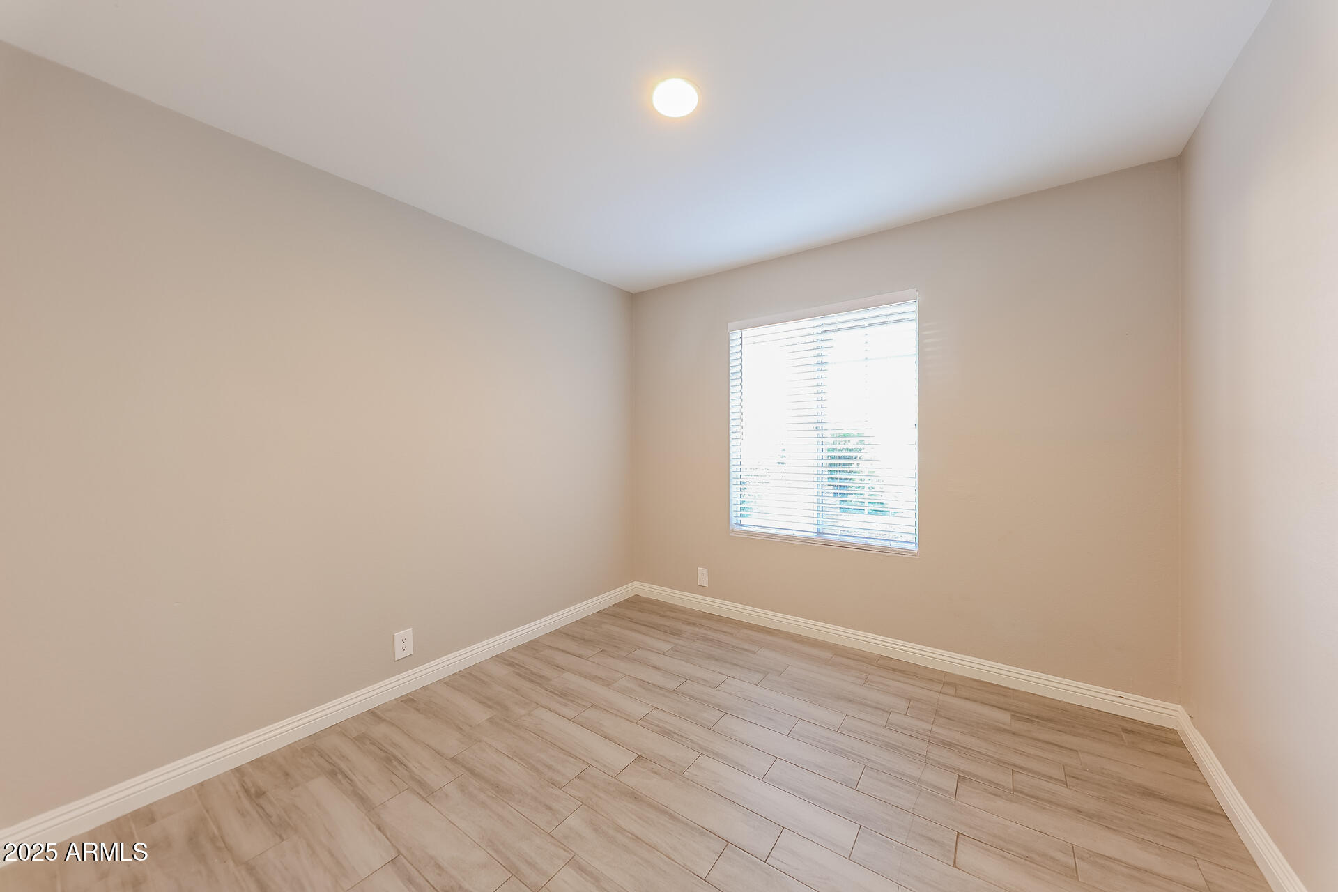 8833 West Monte Vista Road Phoenix, AZ 85037 - Photo 16 of 21 an empty room with wooden floor and windows