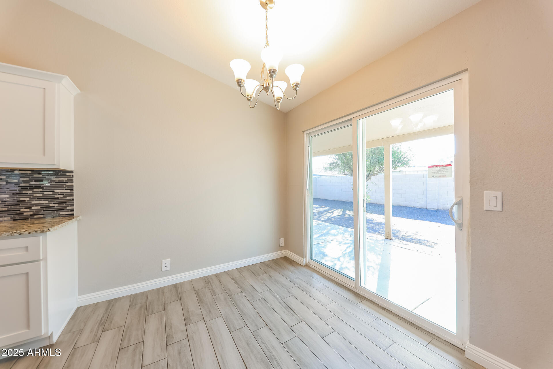 8833 West Monte Vista Road Phoenix, AZ 85037 - Photo 4 of 21 a view of an empty room with wooden floor and a window