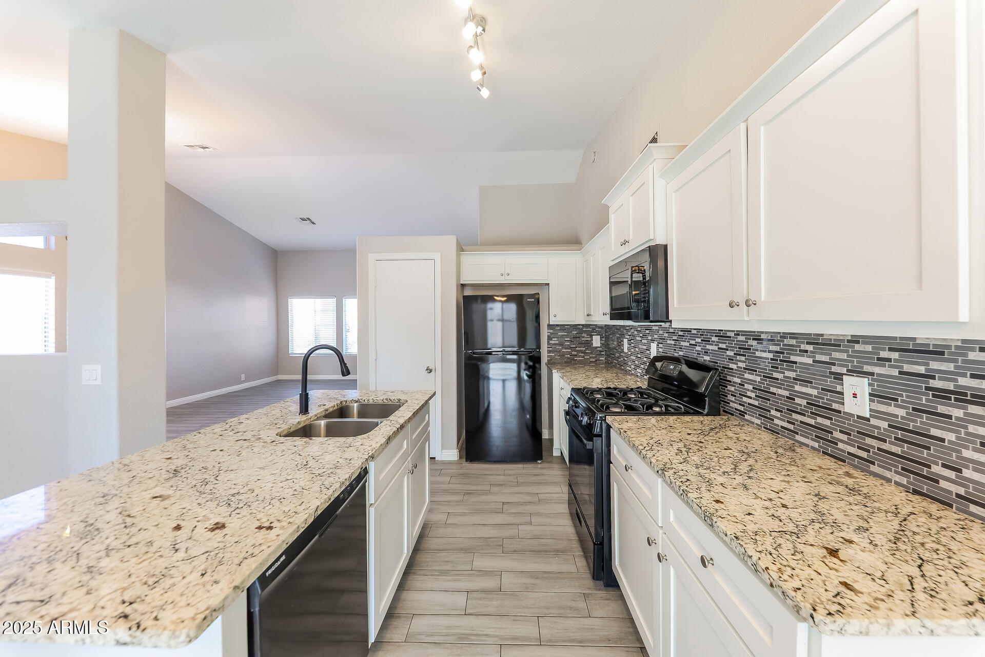 8833 West Monte Vista Road Phoenix, AZ 85037 - Photo 6 of 21 a kitchen with stainless steel appliances granite countertop a sink stove and refrigerator
