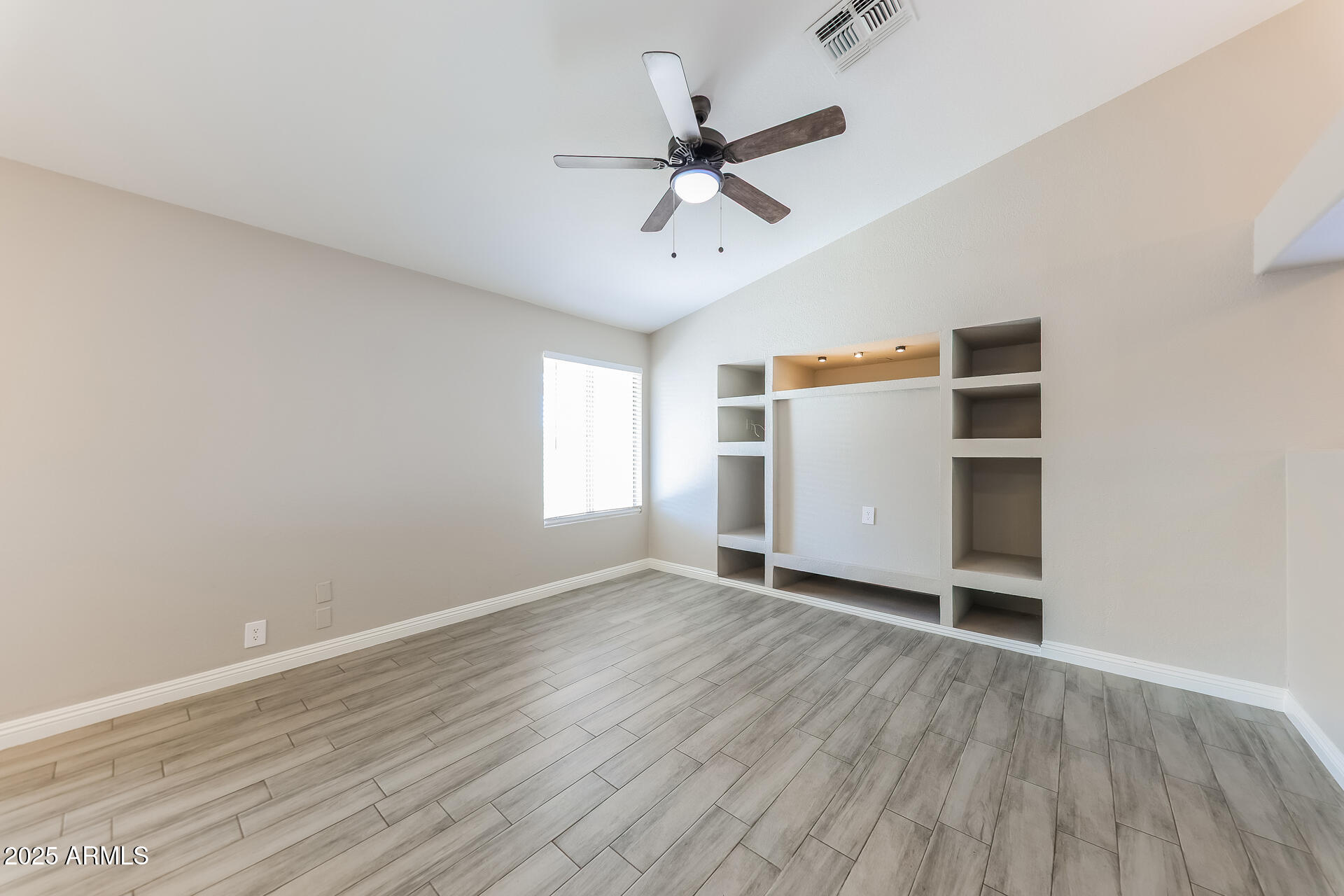 8833 West Monte Vista Road Phoenix, AZ 85037 - Photo 7 of 21 wooden floor in an empty room with a window