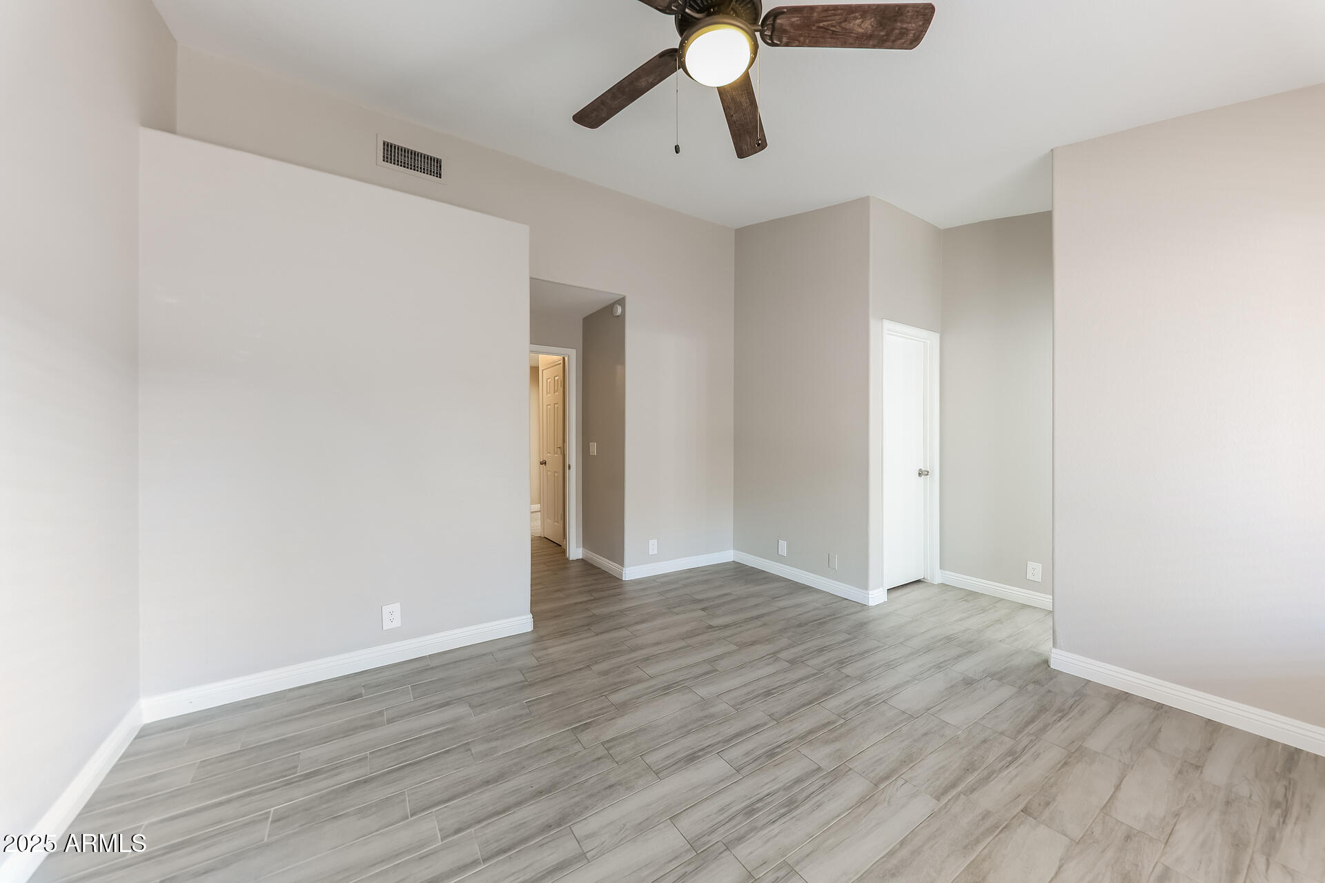 8833 West Monte Vista Road Phoenix, AZ 85037 - Photo 10 of 21 a view of an empty room with wooden floor