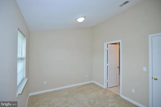 an empty room with closet and mirror