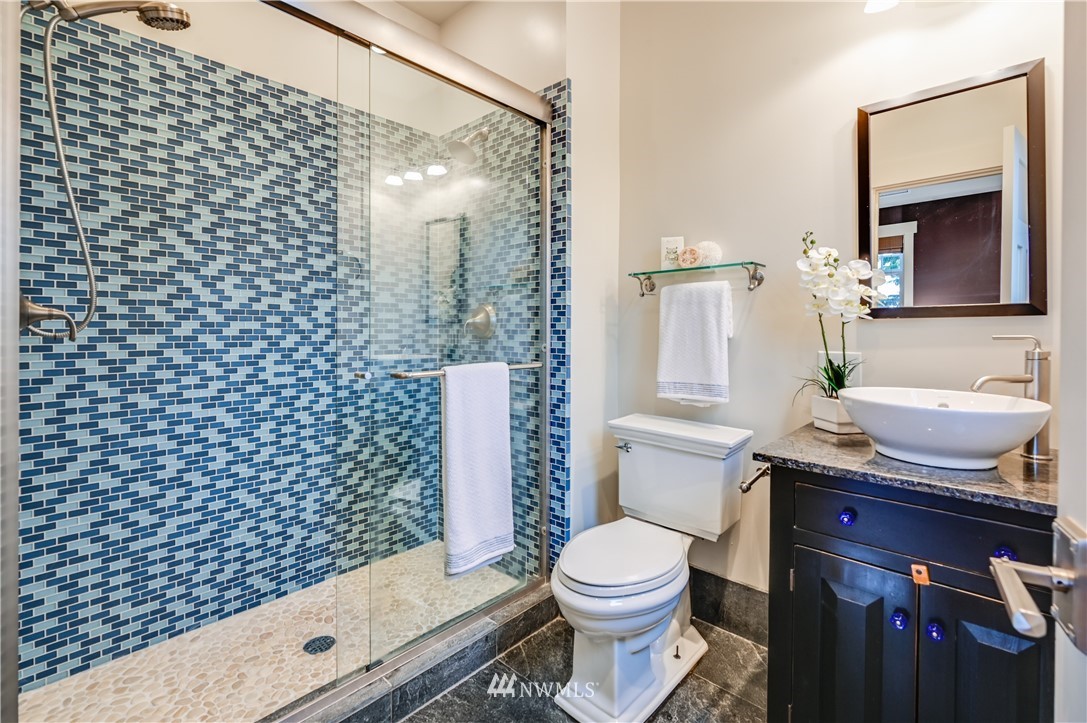 6016 44th Avenue Southwest Seattle, WA 98136 - Photo 23 of 35 a bathroom with a granite countertop toilet a sink and a mirror