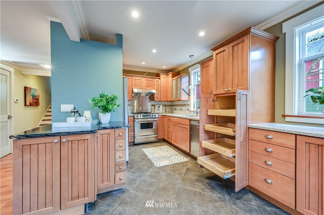 6016 44th Avenue Southwest Seattle, WA 98136 - Photo 10 of 35 a kitchen with granite countertop a refrigerator and cabinets