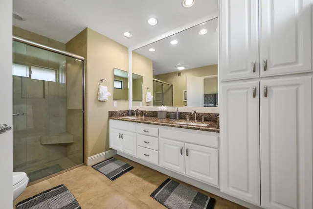a bathroom with a granite countertop sink a toilet and shower