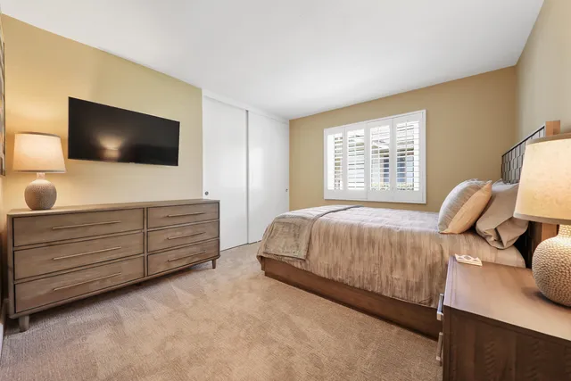 a bedroom with a bed and flat screen tv