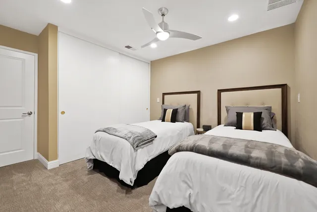 a bedroom with two beds and a chandelier