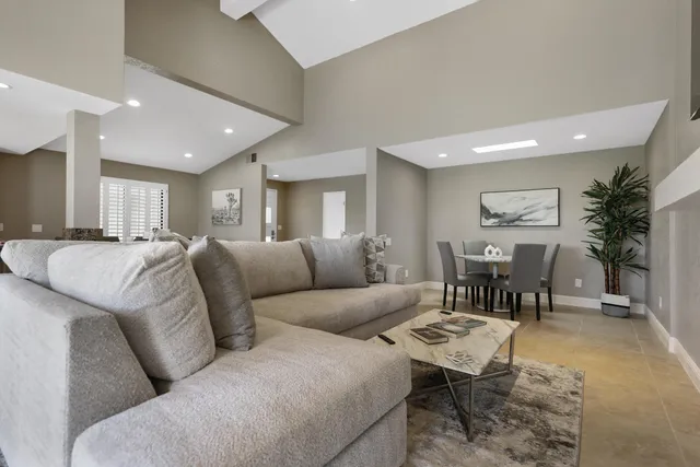 a living room with furniture a dining table and a potted plant