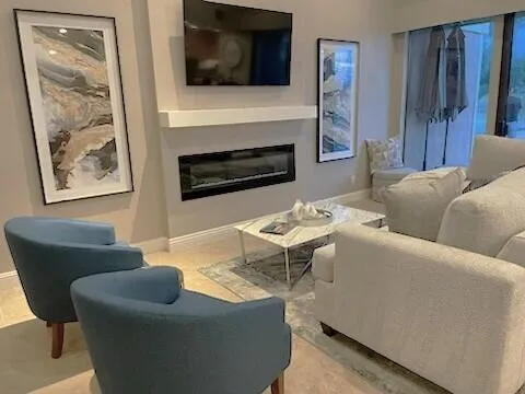 a living room with furniture a flat screen tv and a fireplace