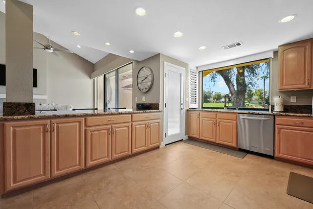 a large kitchen with a large window and white stainless steel appliances