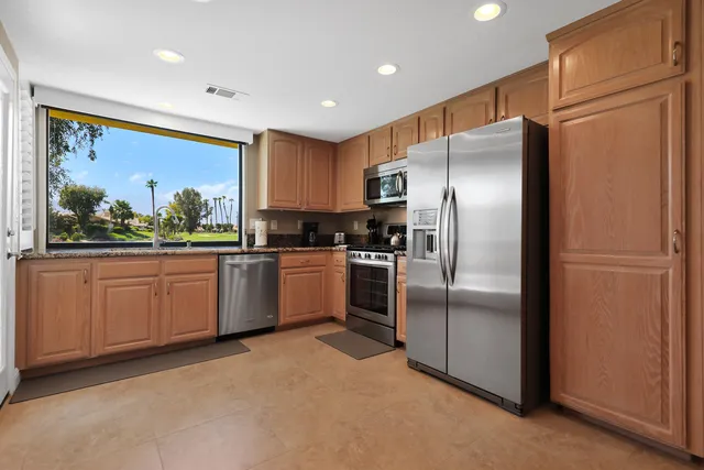 a kitchen with a refrigerator a sink and cabinets