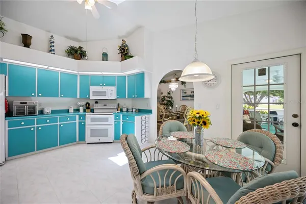 a outdoor dining room with furniture a kitchen island furniture and a chandelier