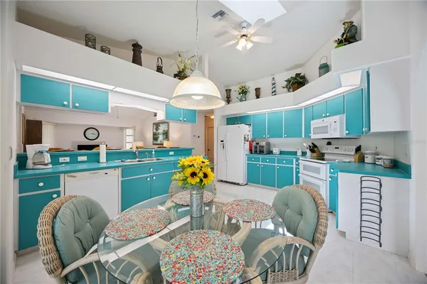 a kitchen with stainless steel appliances kitchen island granite countertop a dining table chairs in it and a window