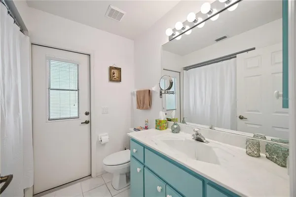 a bathroom with a granite countertop sink toilet and mirror
