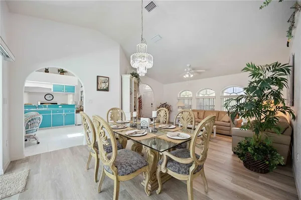 a dining room with furniture potted plants and wooden floor