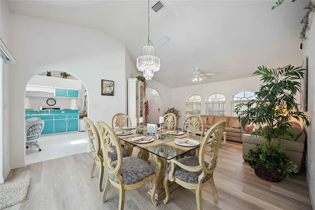 a dining room with furniture potted plants and wooden floor