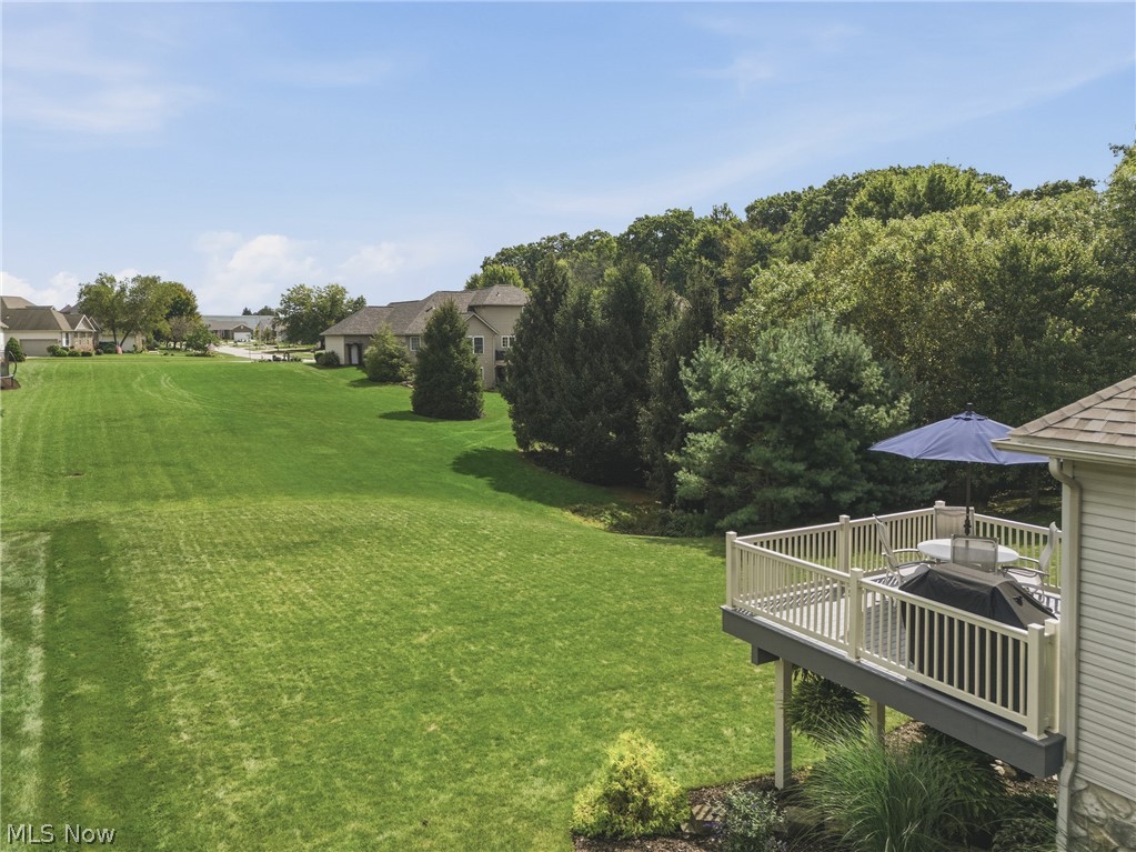 3955 Spring Brook Way Wooster, OH 44691 - Photo 45 of 50 Expansive green lawn, elevated composite deck with white railings, and mature trees bordering the property