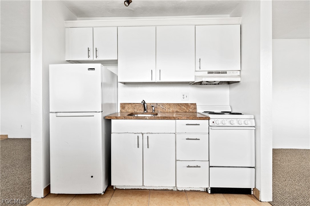 8141 Country Road, Unit 202 Fort Myers, FL 33919 - Photo 19 of 22 a kitchen with cabinets appliances and a fridge