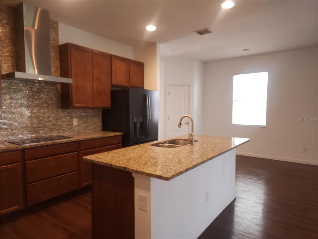 3230 Stratton Circle Kissimmee, FL 34744 - Photo 10 of 28 a kitchen with stainless steel appliances granite countertop a sink stove and refrigerator