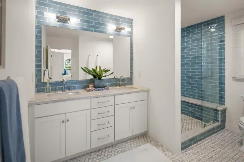 a bathroom with a granite countertop sink a mirror and shower