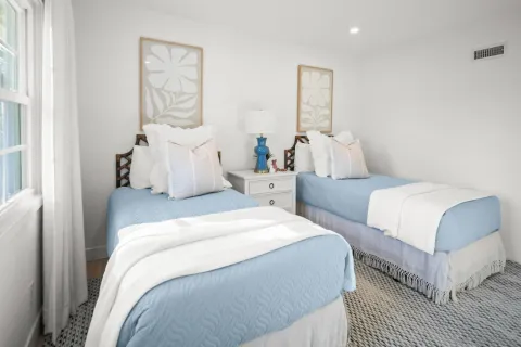 a bedroom with two beds and a painting