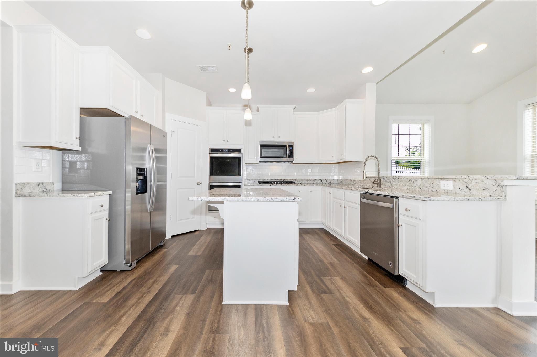2003 Foster Way Frederick, MD 21702 - Photo 21 of 74 a kitchen with stainless steel appliances kitchen island granite countertop a refrigerator a stove top oven a sink dishwasher and white cabinets with wooden floor