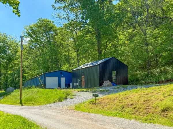 a front view of house with yard and trees in the background