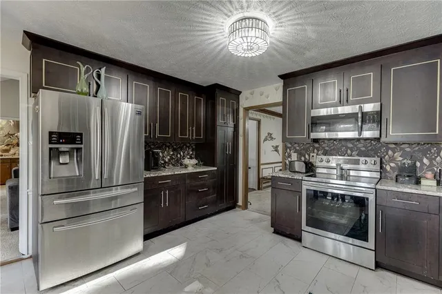 a kitchen with stainless steel appliances granite countertop a sink and stove