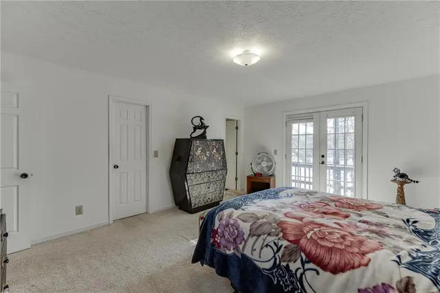 a bedroom with a bed a dresser and flowerpot