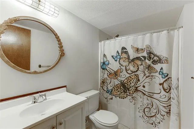 a bed sitting in a spacious bedroom next to a window