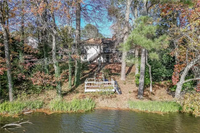 an aerial view of a house with a yard and lake view