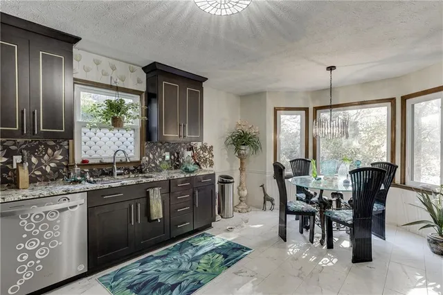 a kitchen with stainless steel appliances granite countertop a sink and stove top oven