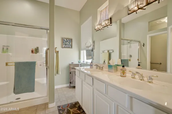 a bathroom with a double vanity sink mirror and shower