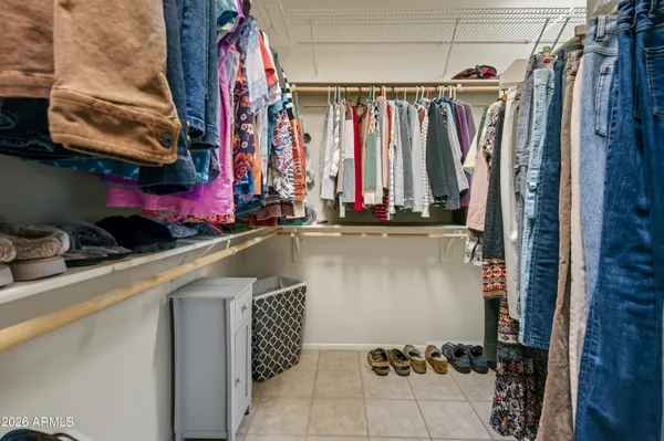 a view of walk in closet with clothes and shoes