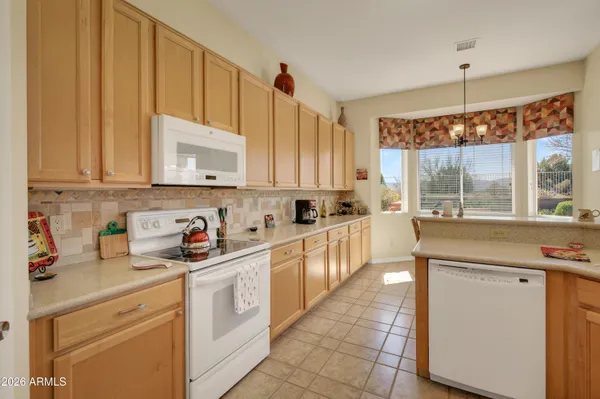 a kitchen with stainless steel appliances a stove a sink and white cabinets