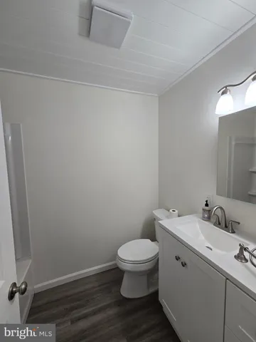 a bathroom with a toilet a sink and mirror