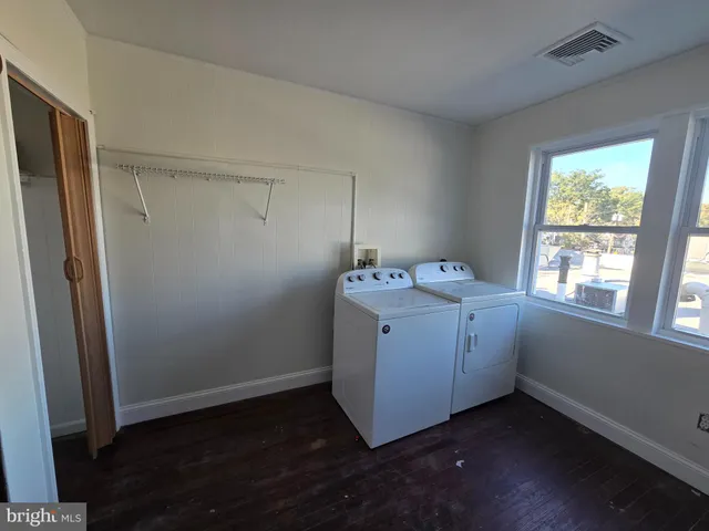 a utility room with wooden floor washer and dryer