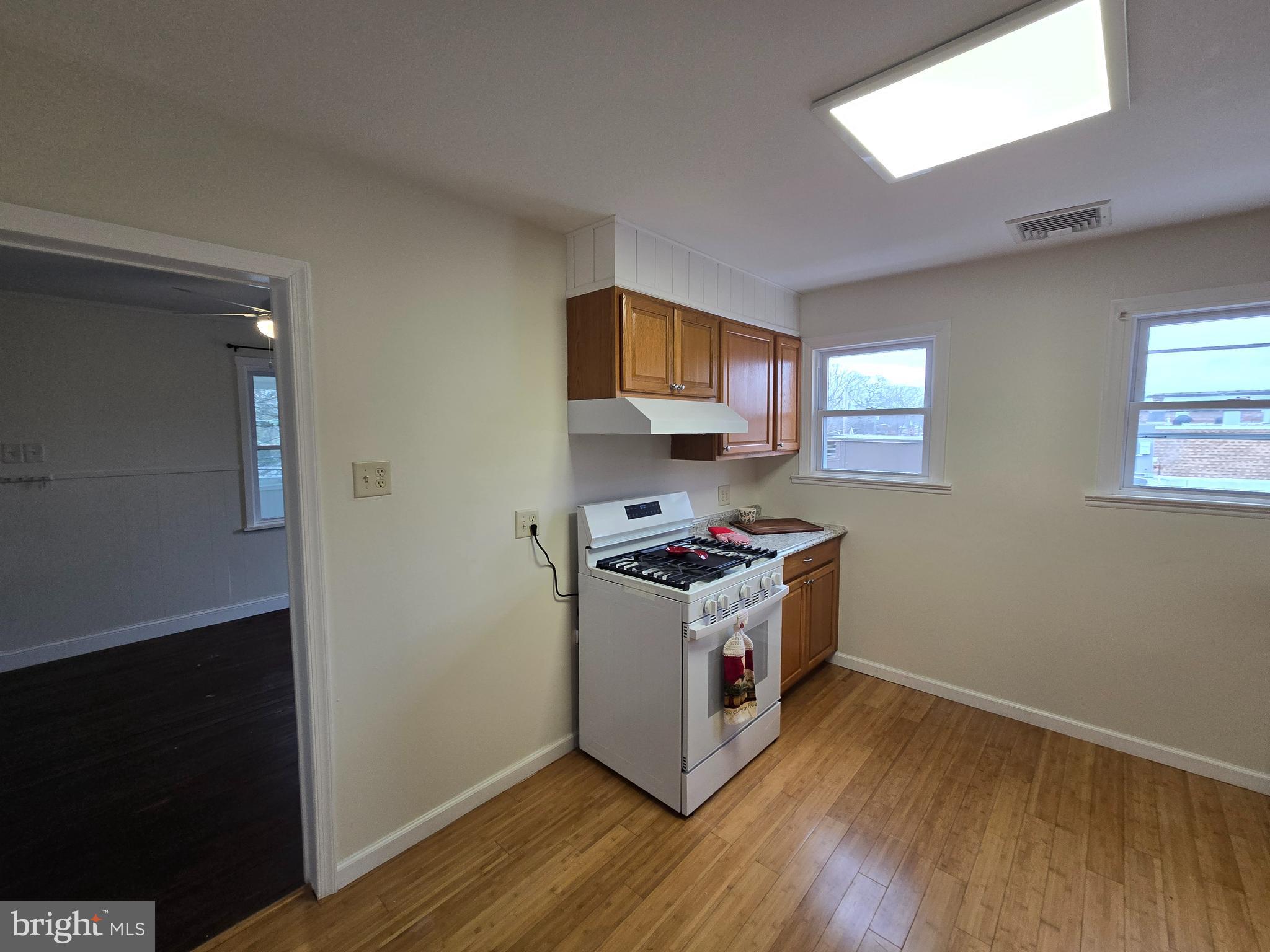 130 South Broadway Pitman, NJ 08071 - Photo 3 of 11 a kitchen with wooden floor and a stove